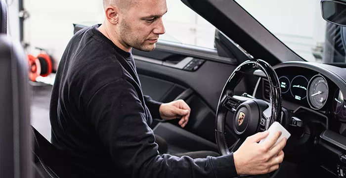 Person bei der Auto Lederpflege